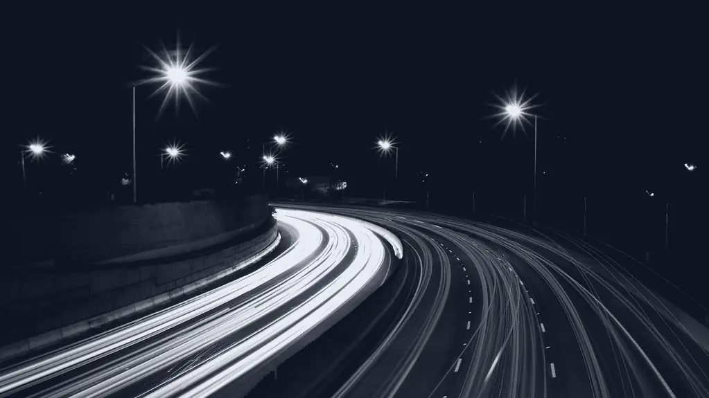 A road at night, headlights drawn out into streaks