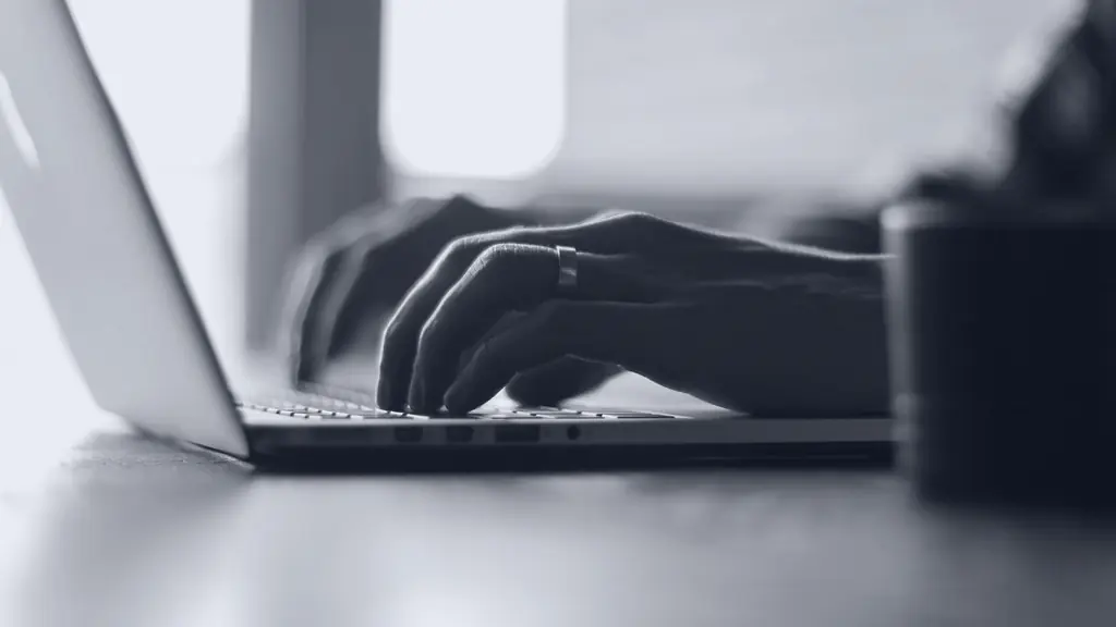 Hands typing on a laptop keyboard