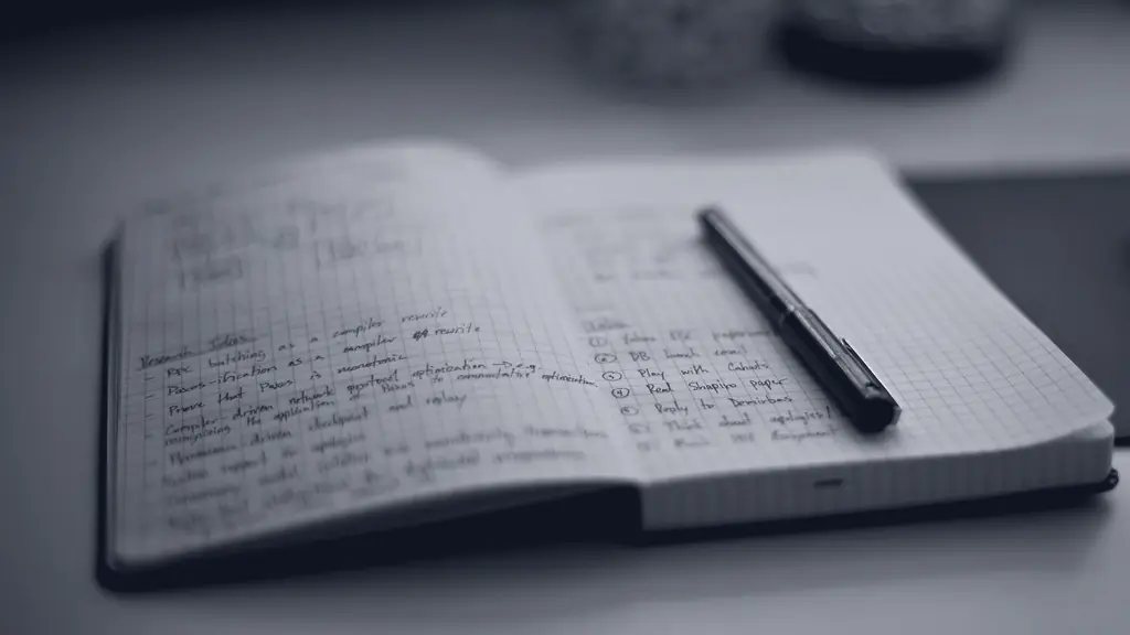 An open notebook covered in handwriting, a pen across it